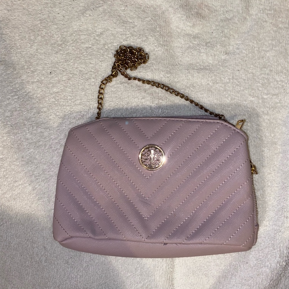 Purple cross body bag with gold straps and many pockets.